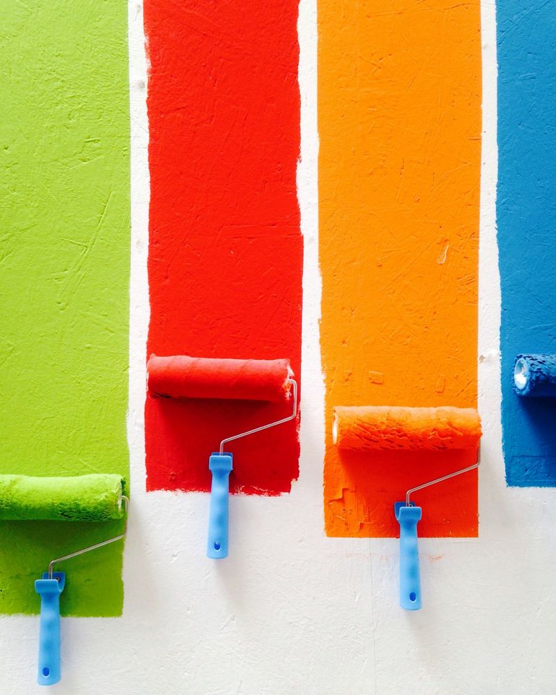 Rolos de pintura com faixas coloridas